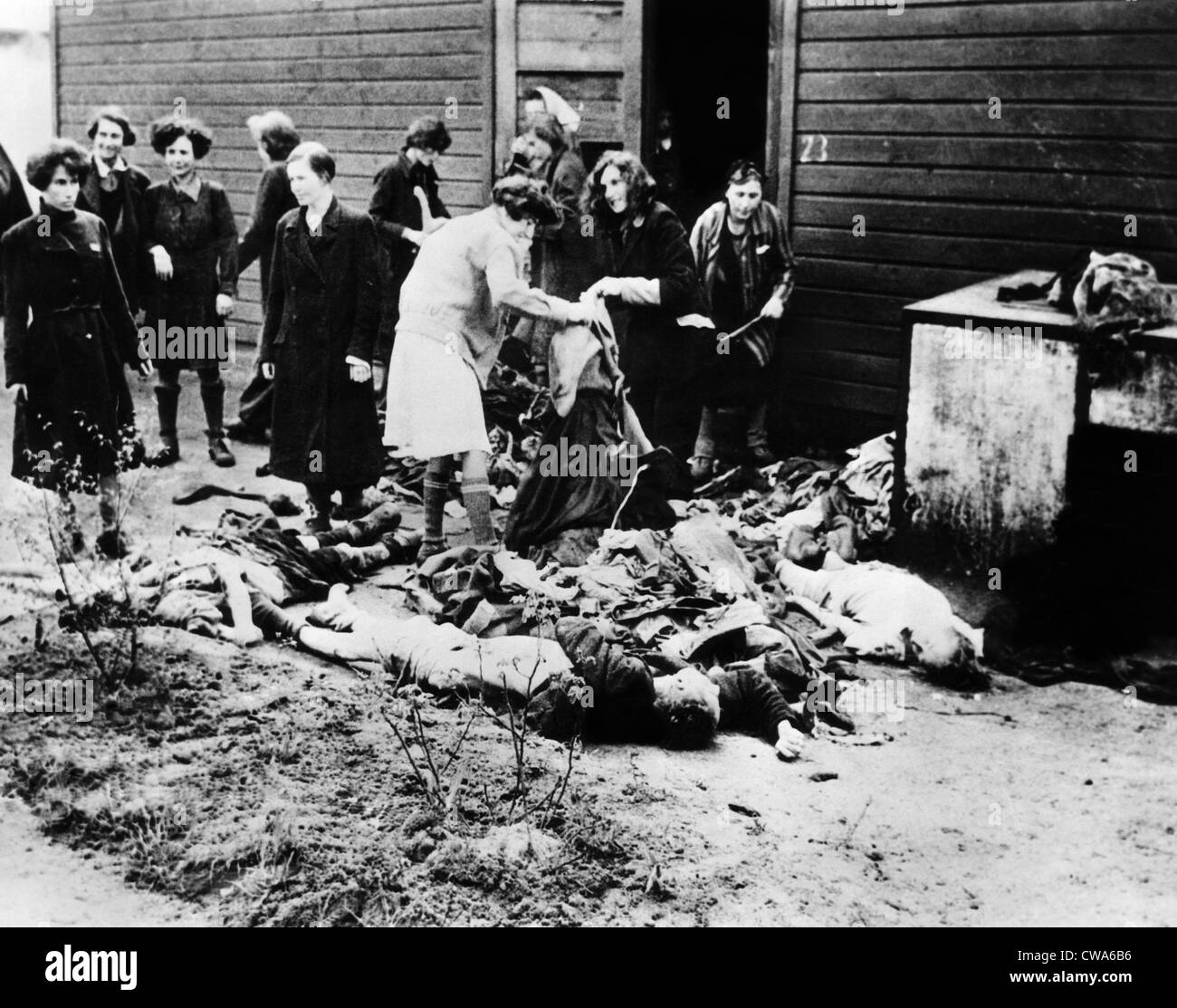 Les femmes allemandes prendre vêtements de la victimes au camp de concentration de Belsen. Des civils ont été contraints de voir les atrocités après il Banque D'Images