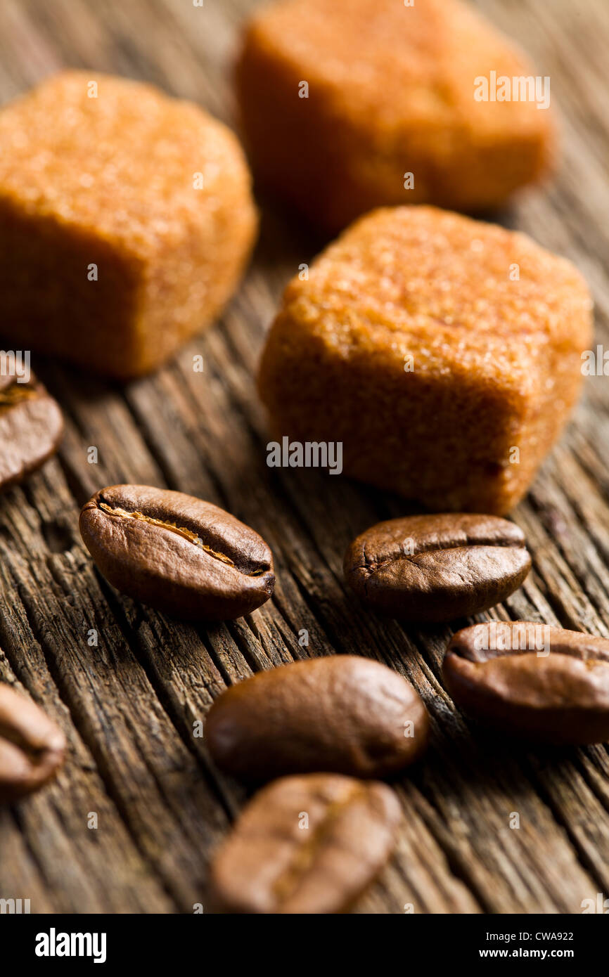 Les grains de café avec du sucre brun cubes on wooden table Banque D'Images
