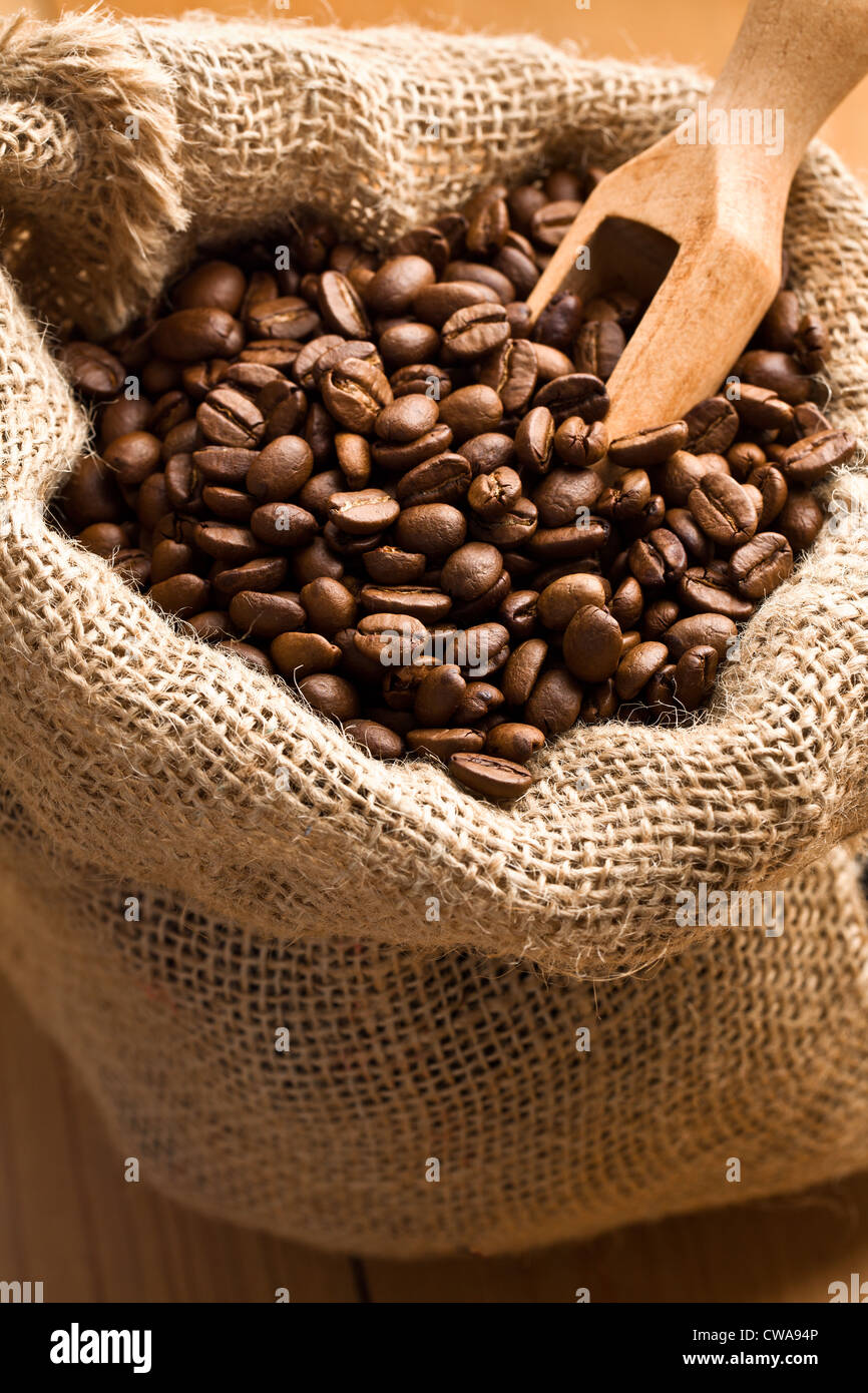 Les grains de café en sac de toile avec du scoop Banque D'Images