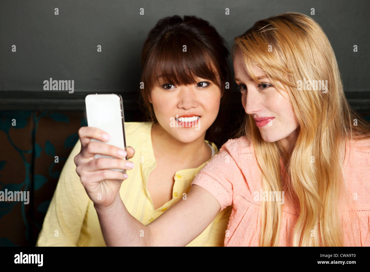 Amis féminins photographier eux-mêmes sur le smartphone. Banque D'Images