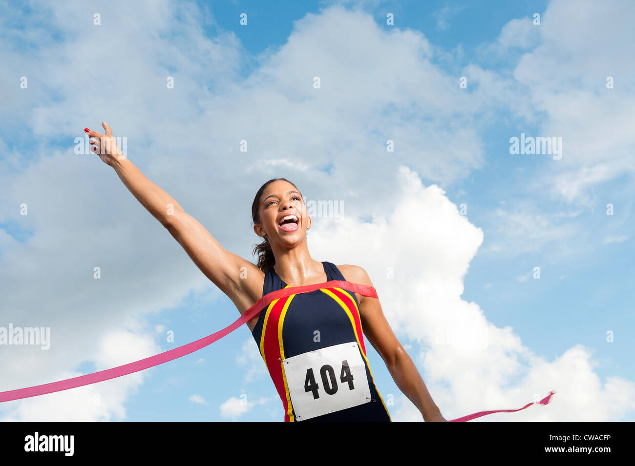 Athlète féminin de franchir la ligne d'arrivée Banque D'Images