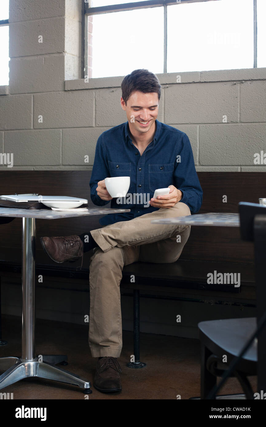 Businessman texting in cafe Banque D'Images