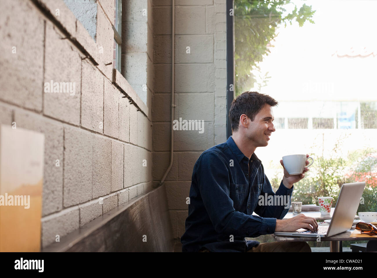 Businessman using laptop in cafe Banque D'Images