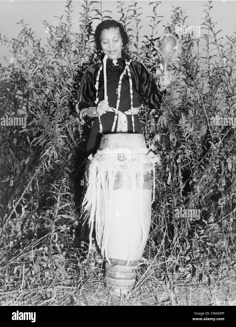 Zora Neale Hurston (1891-1960), auteur américain et spécialiste de l'Afrique, en battant le hountar, mama ou tambour. 1937. Banque D'Images