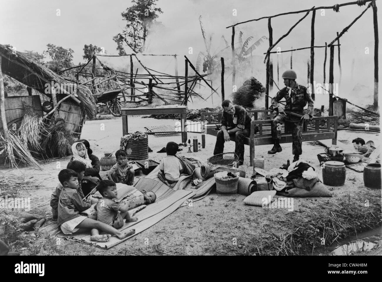 Femme sud-vietnamiens et les enfants s'asseoir au milieu des ruines de leur village, brûlé par les troupes gouvernementales étaient soupçonnés d'un Viet Banque D'Images