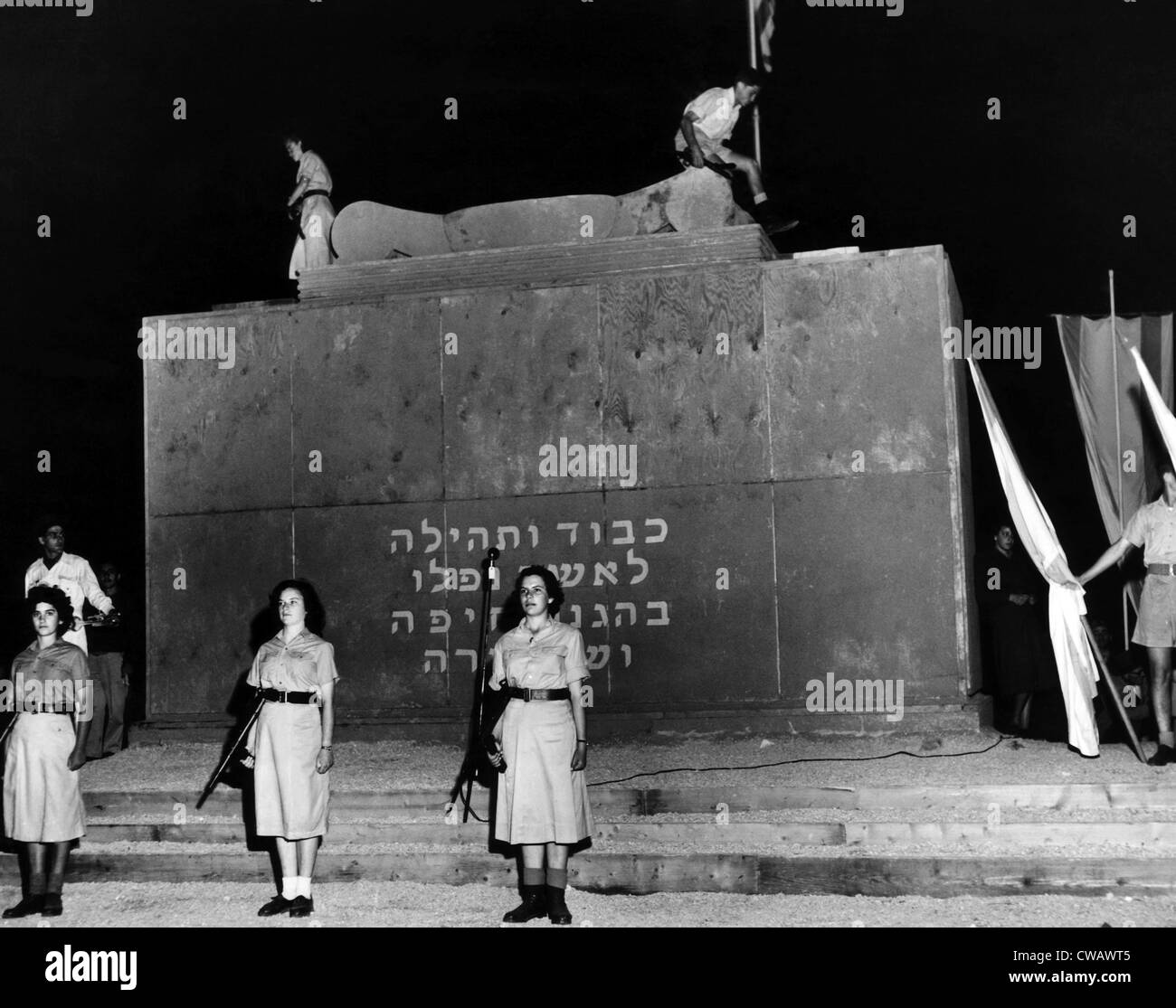 Deux jeunes allumer la flamme éternelle sur haut de Haïfa's monument en l'honneur de ceux qui ont été tués dans la bataille pour l'Haïfa un an plus tôt. Banque D'Images