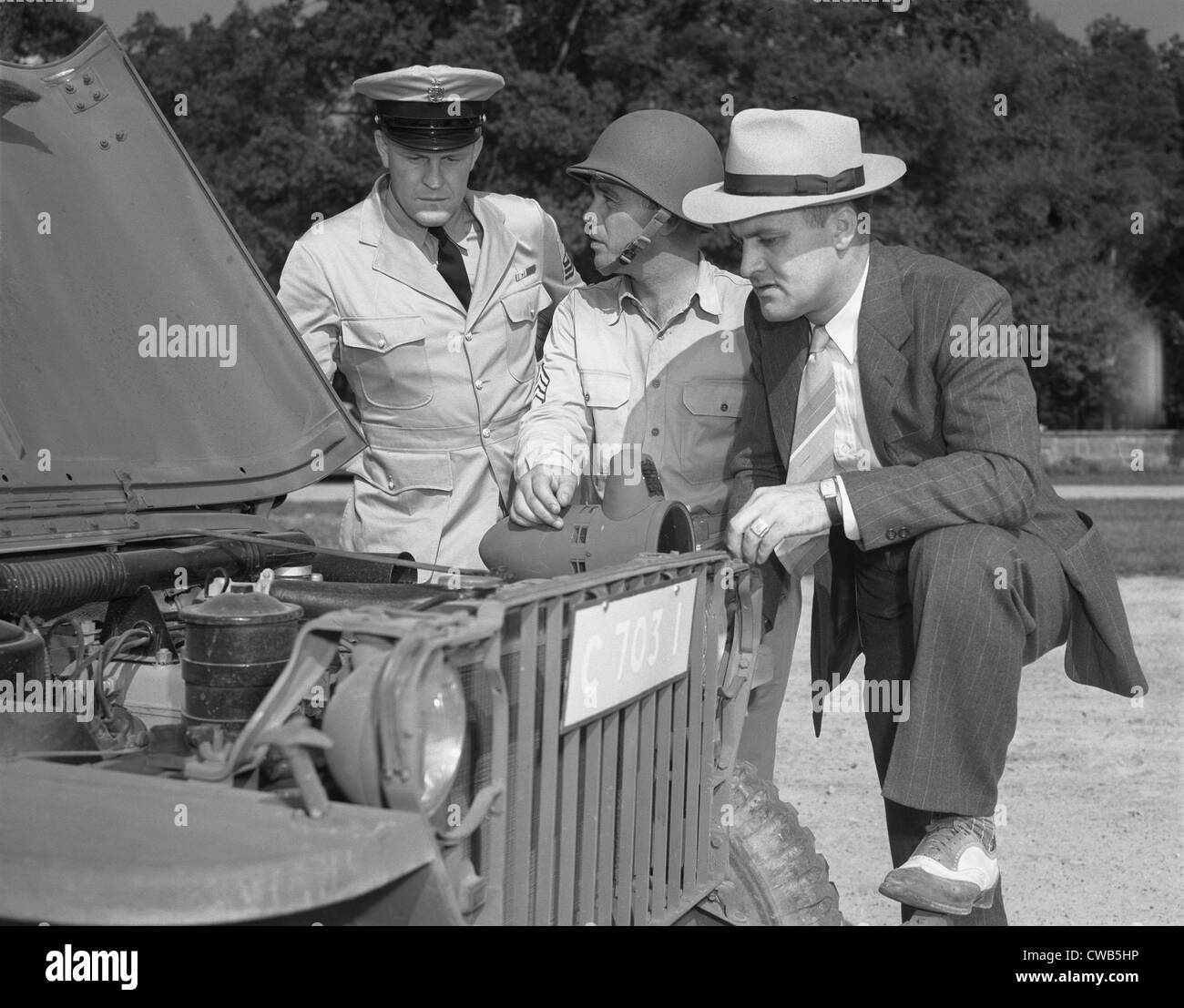 La Seconde Guerre mondiale, George Woolslayer (droite) l'examen d'une jeep de l'armée à la barrière où le Sergent Français L. Vineyard (centre) est Banque D'Images