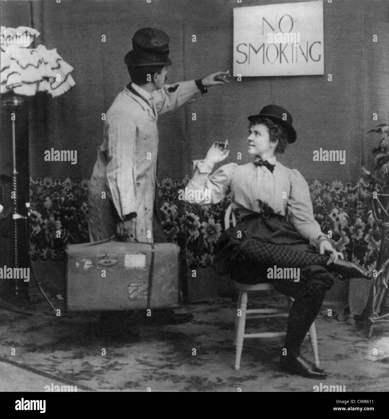 Scène humoristique de l'homme pointant à aucun signe de fumer au-dessus de  femme en derby et bloomers qui fume cigarette, photographie, 1897 Photo  Stock - Alamy