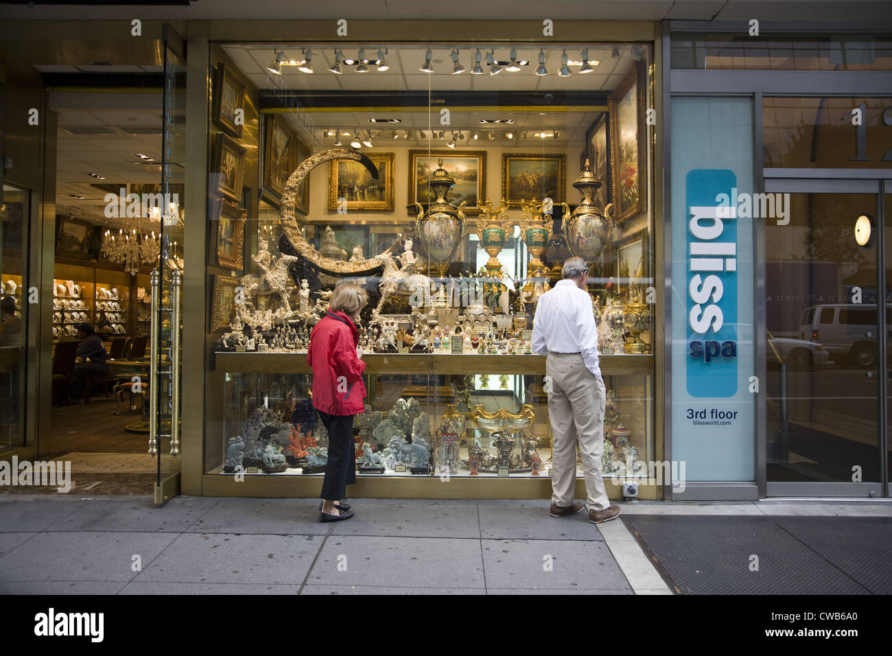 Les gens d'admirer les pièces affichées à un antiquaire le long de la 57th Street à Manhattan Banque D'Images