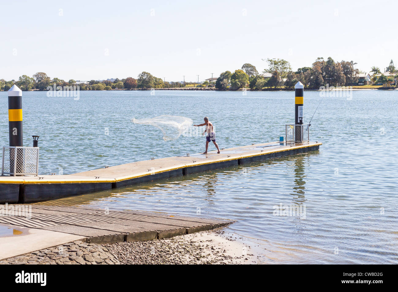 L'homme d'un filet de pêche d'appâts sur une jetée flottante à Maroochy River, Maroochydore sur la Sunshine Coast, Queensland, Australie Banque D'Images
