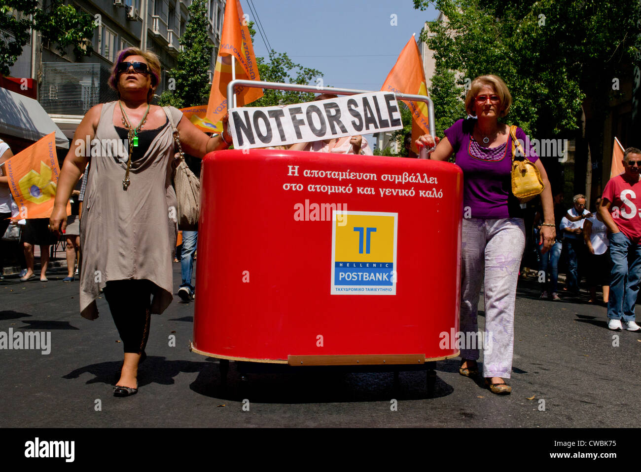 Les employés de l'Hellenic Postbank mars contre la privatisation prochaine de la banque. Ils portent un géant de l'argent fort. Banque D'Images