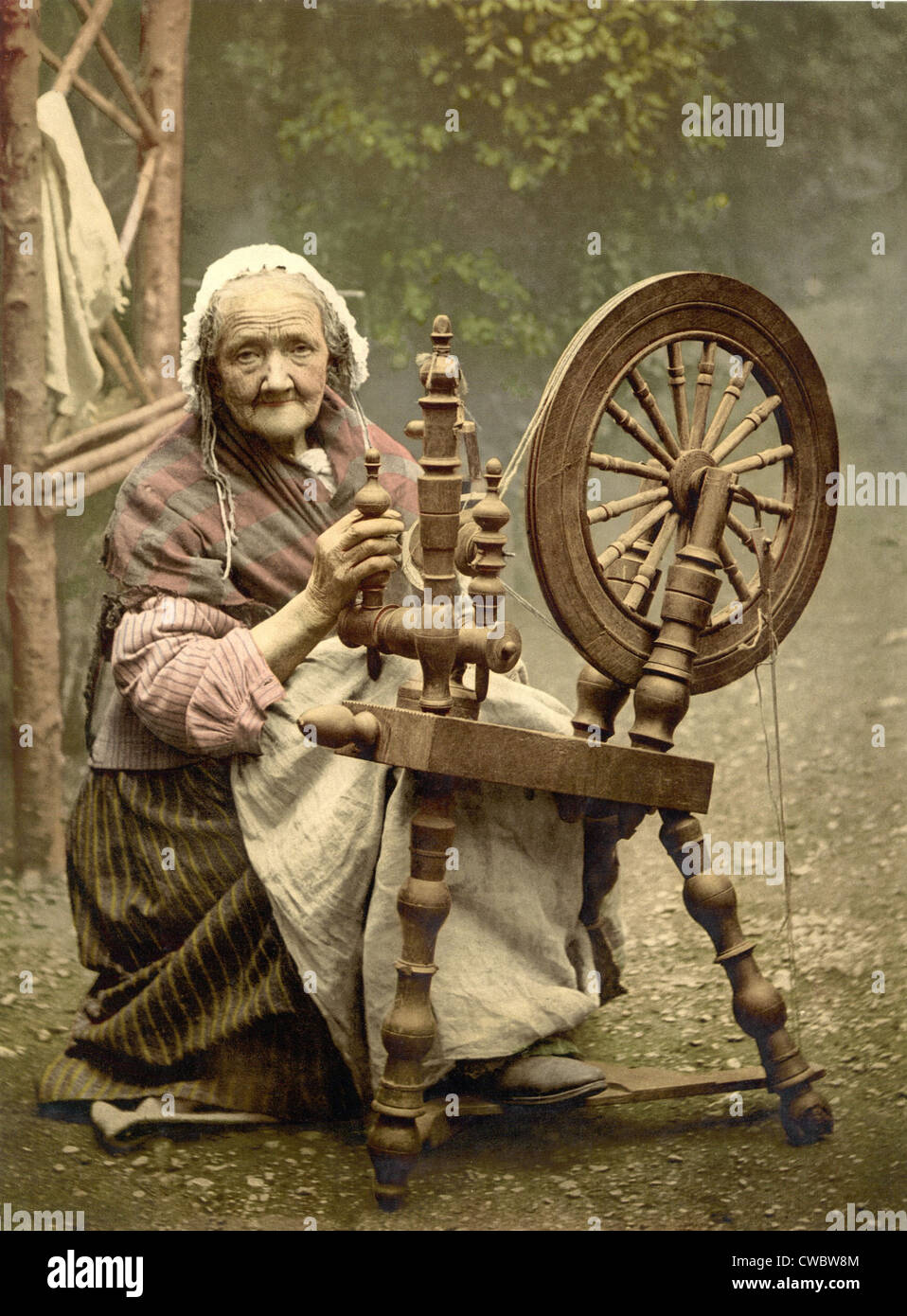 Personnes âgées Spinner irlandais de travail à l'extérieur à son rouet à la fin du xixe siècle. Bien que pittoresque, comme la filature accueil Banque D'Images