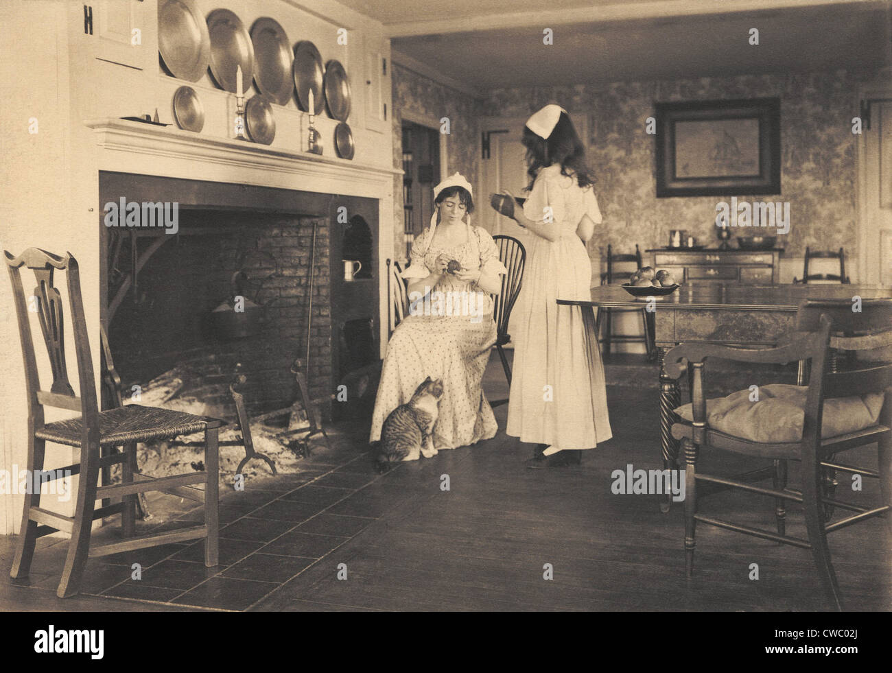 Les loisirs d'un gentile maison coloniale américaine avec deux femmes en costume d'époque coloniale. 1913 Photo par Wallace Nutting. Banque D'Images