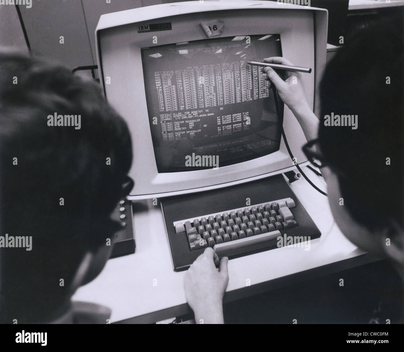 Les programmeurs IBM travaillent à un moniteur cathodique à écran tactile avec un pointeur. Ca. 1980. Banque D'Images