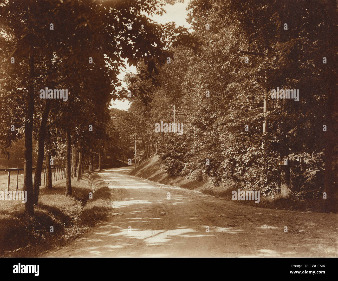 Une route ensoleillée, par Edward Curtis. 1904 Cette photo montre tout droit nouveau poteaux espacés le long de la route de campagne. Il faudrait Banque D'Images