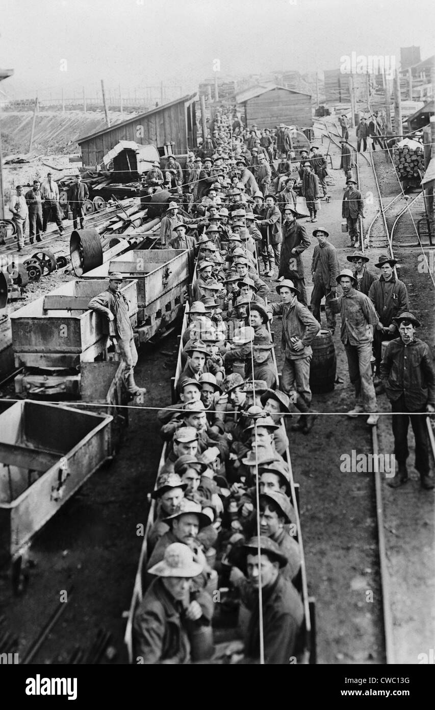 Des dizaines d'hommes dans des wagons ouverts sur leur chemin dans les mines souterraines de l'Idaho en 1909. Banque D'Images