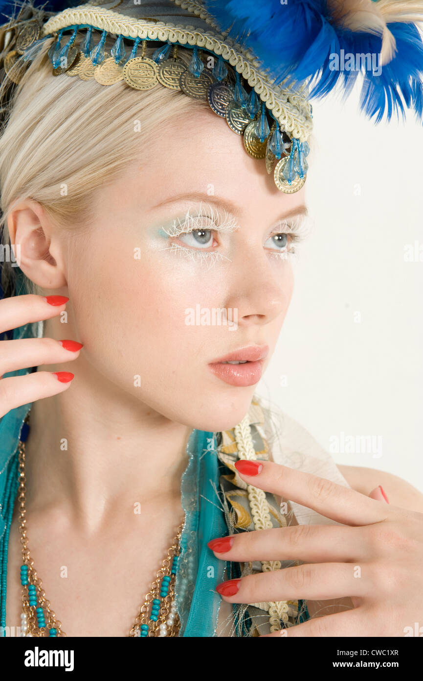 Close-up of young female portant une coiffe de plumes à la suite Banque D'Images