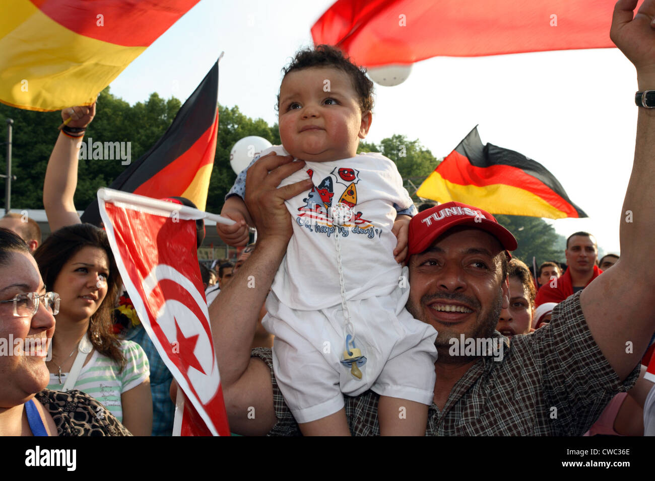 Les amateurs de soccer World Cup 2006 : grand-père tunisien avec bébé entre les fanions Banque D'Images