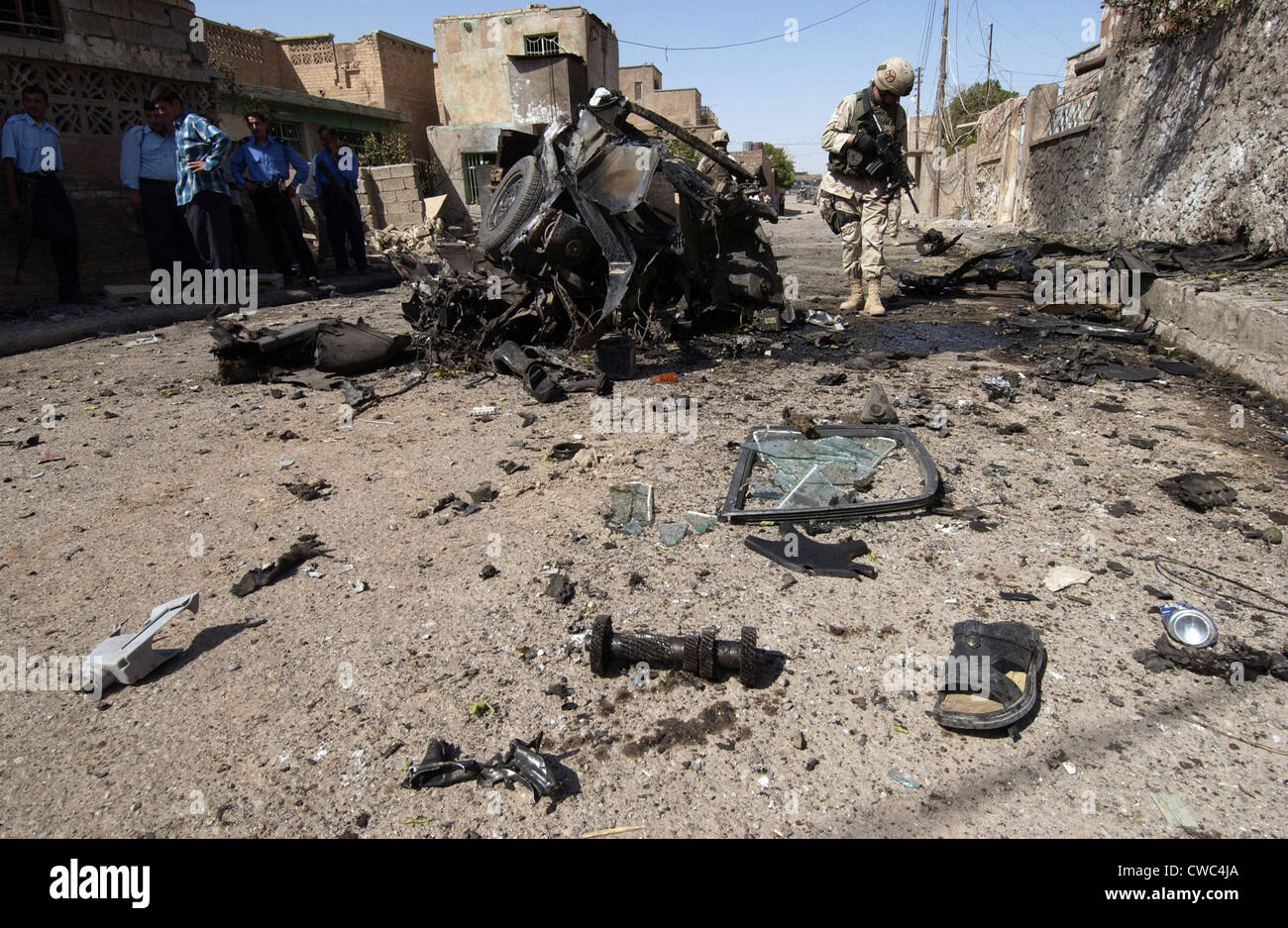 Soldat nous inspecte la zone autour du véhicule d'un attentat-suicide en Irak. Tuz Le kamikaze s'est tué quatre civils blessés Banque D'Images