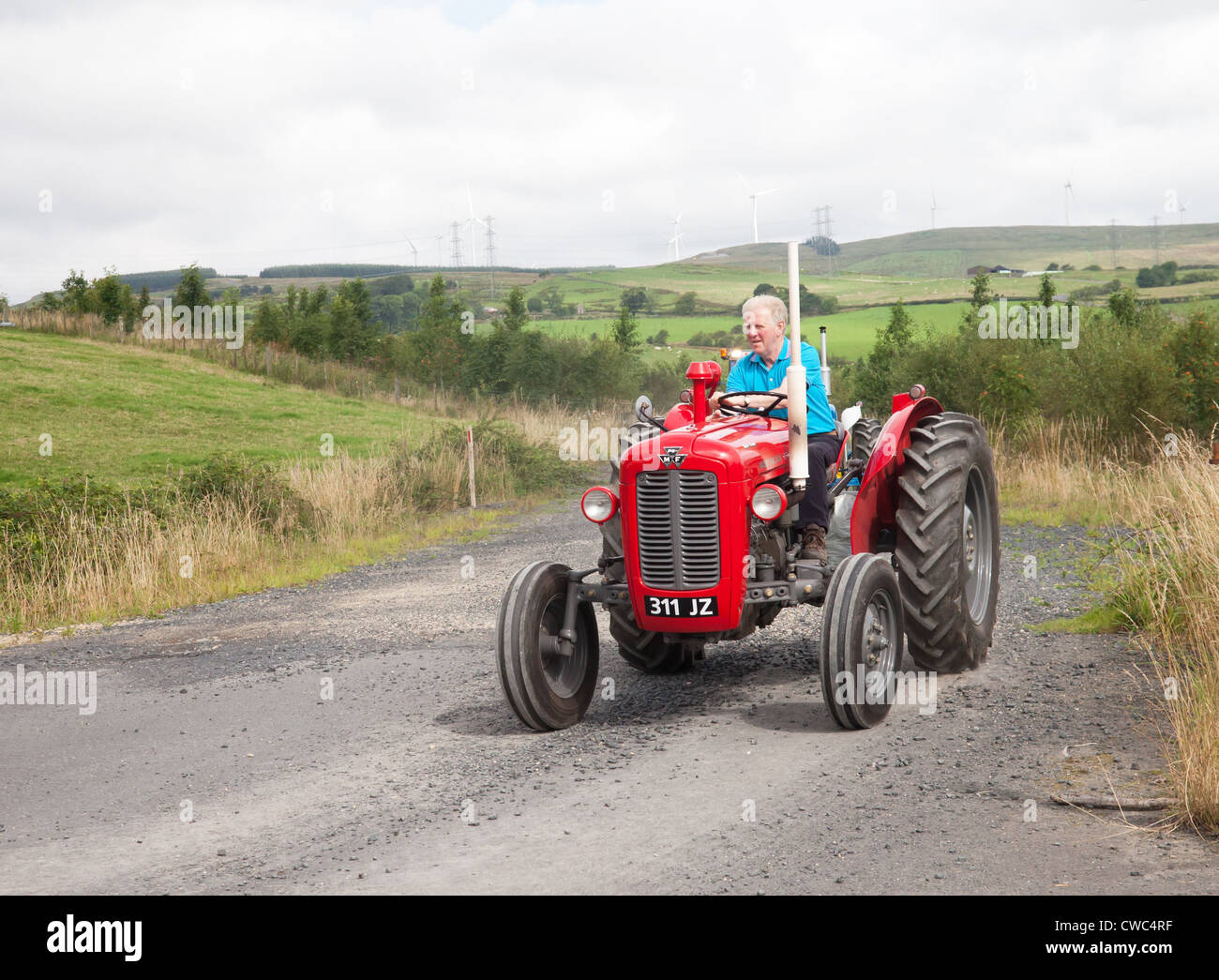 La conduite d'un amateur de Massey Ferguson tracteur vintage rouge 35X au cours d'une machine et de tracteur Vintage Ayrshire Club road run Banque D'Images