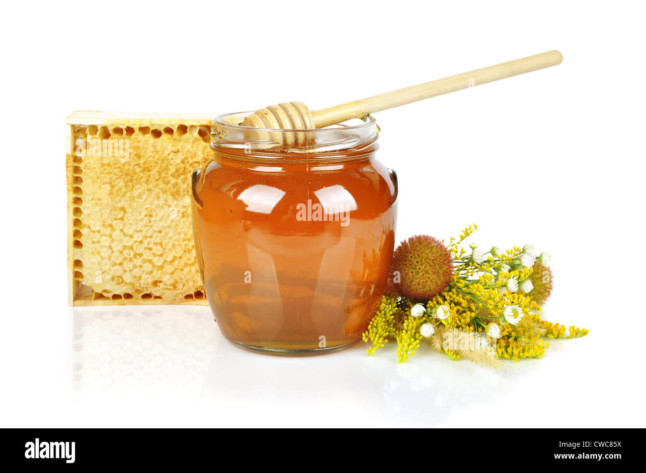 Le miel sucré dans un bocal en verre avec du miel goutteur, miel frais en peigne et bouquet de fleurs sauvages Banque D'Images