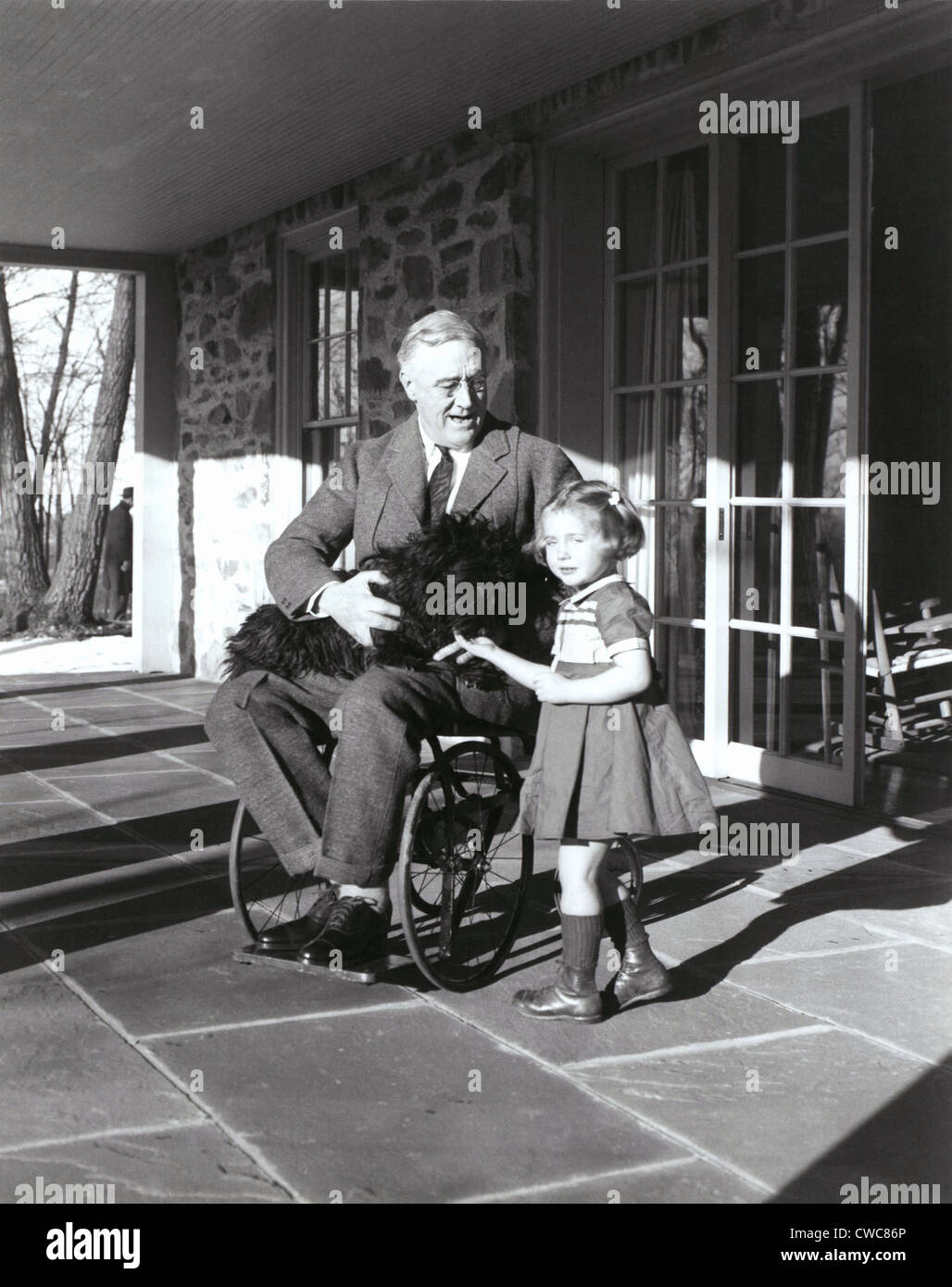 Le président Roosevelt dans son fauteuil roulant sur le porche à Top Cottage dans Hyde Park NY avec Ruthie Bie et Fala. Photo a été prise par Banque D'Images