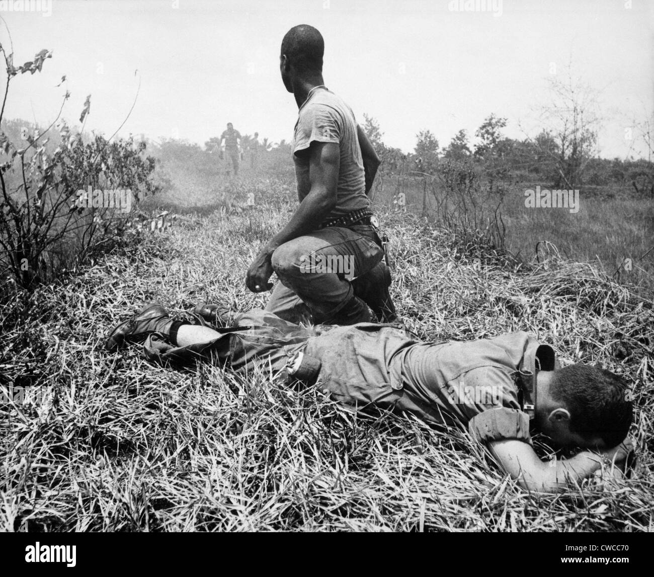 Guerre du Vietnam. Un Africain l'infanterie américaine medic traite une jambe du lieutenant, qui a été brûlé par l'explosion d'un Viet Cong white Banque D'Images