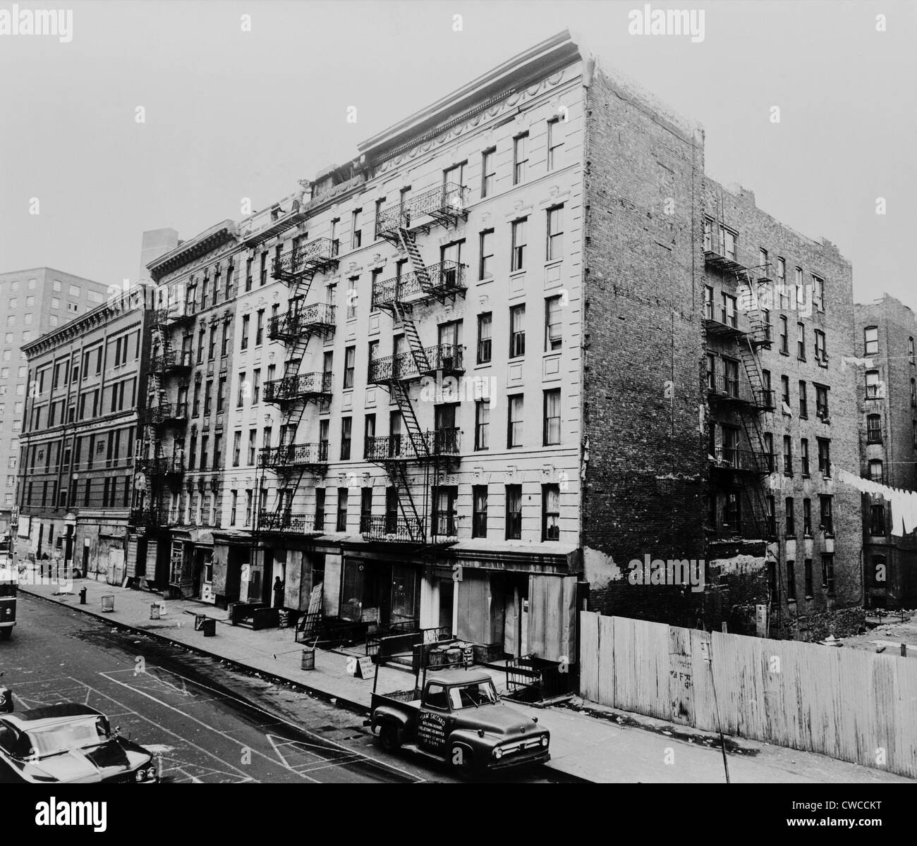 East Harlem street et grand immeuble immeuble au 311 East 100th Street, à New York. 1964. Banque D'Images