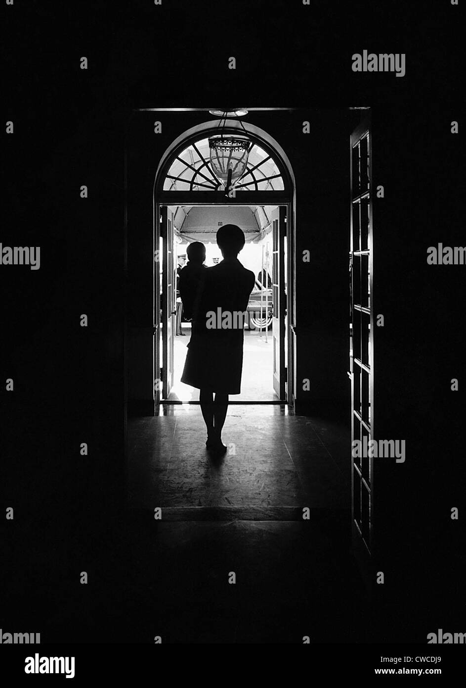 Portrait Silhouette de Jacqueline Kennedy portant son fils âgé d'un an, John Kennedy Jr. à la Maison Blanche, portique sud Banque D'Images