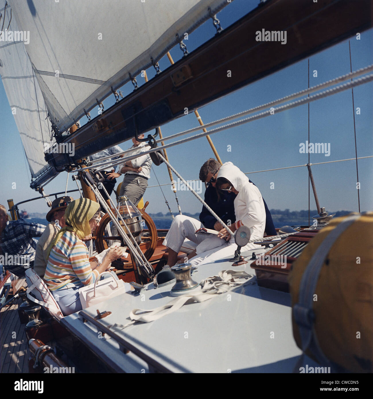Président et Jacqueline Kennedy la voile avec ses parents, Janet et Hugh Auchincloss. Jackie Kennedy est le tabagisme et la lecture Banque D'Images