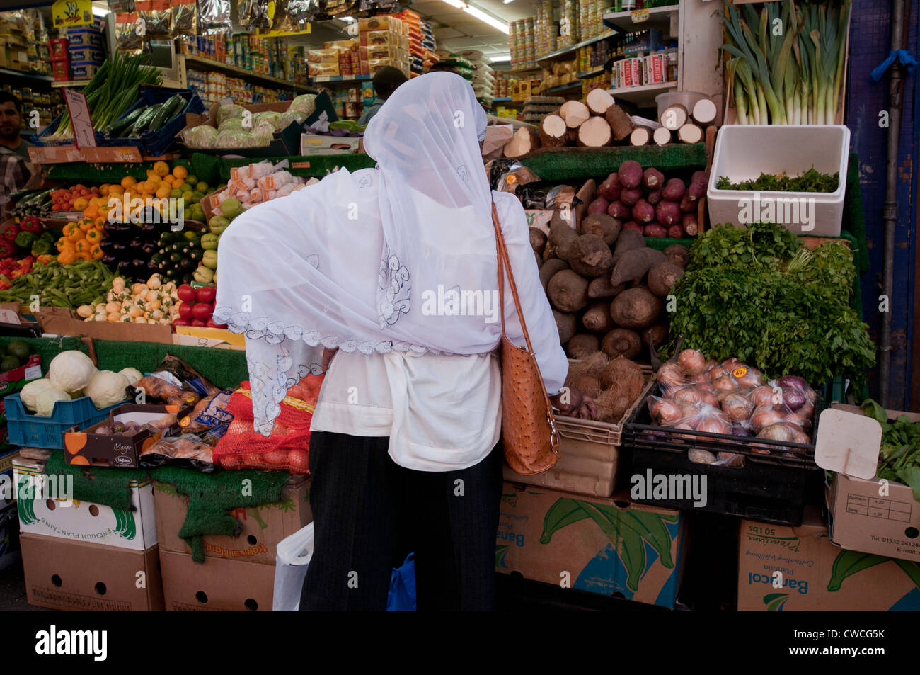 Asian woman buying vegetables in Marché de Brixton Banque D'Images