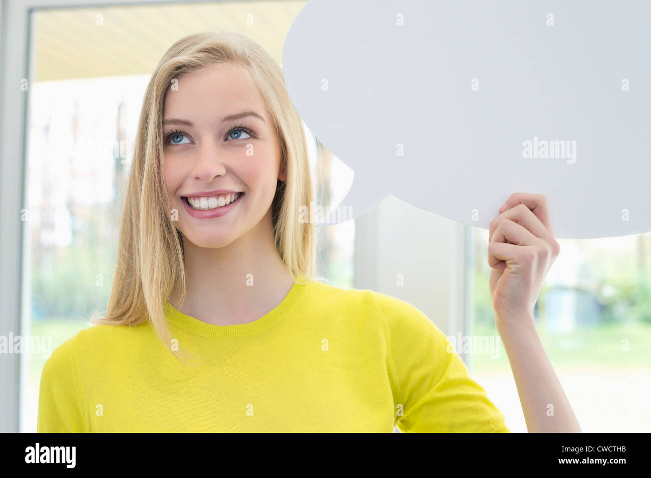 Femme tenant un discours bubble and smiling Banque D'Images