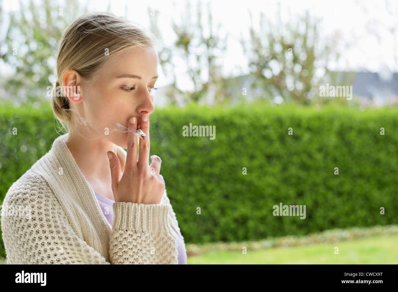 Femme cigarette dans park Banque D'Images