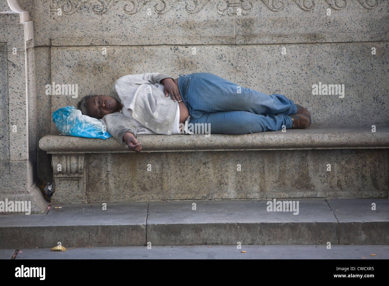 Femme sans-abri se reposant sur un banc à l'extérieur de la NY Public Library (42e st & 5th Avenue à New York. Banque D'Images