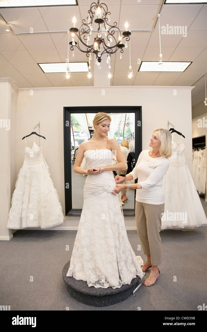 Belle femme déguisée en mariée avec employé supérieur aider en magasin nuptiale Banque D'Images