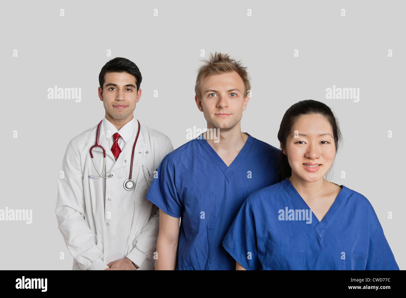 Portrait of multi ethnic medical team standing sur fond gris Banque D'Images