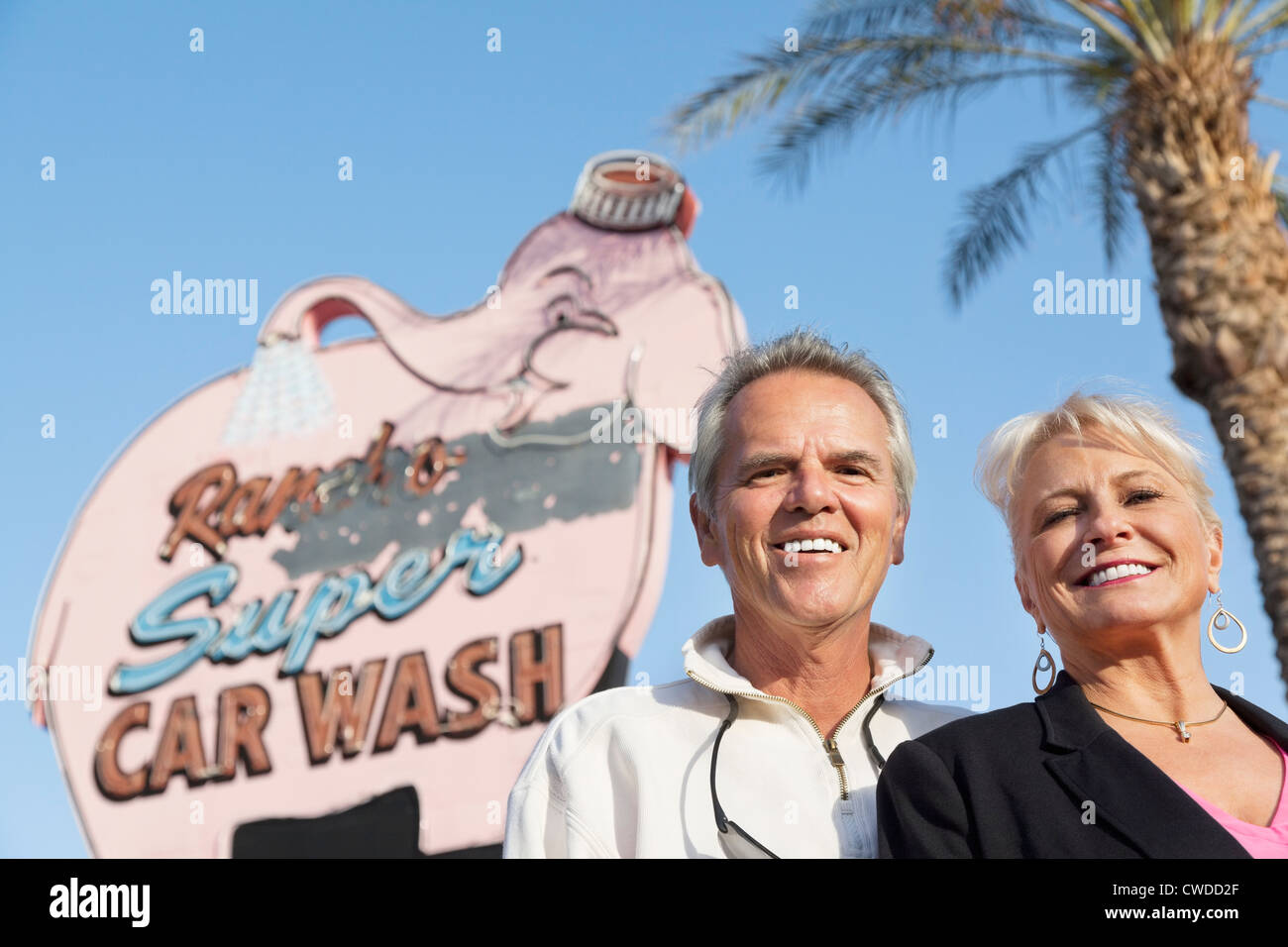 Portrait d'un couple en face de lavage de voiture pancarte Banque D'Images