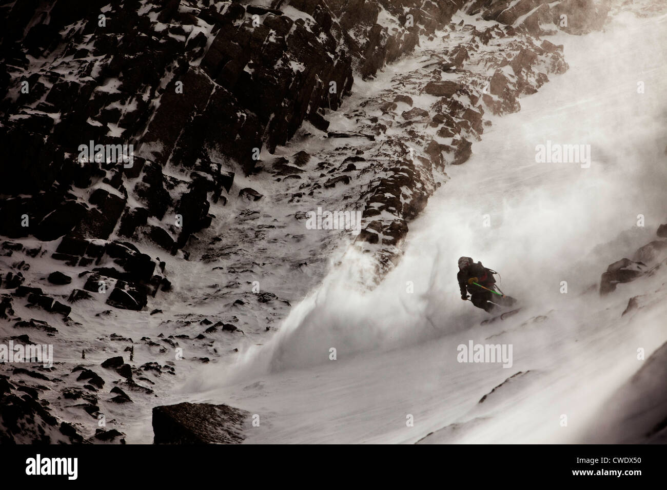 Un skieur athlétiques diminution un rocky mountain dans l'arrière pays dans le Montana. Banque D'Images