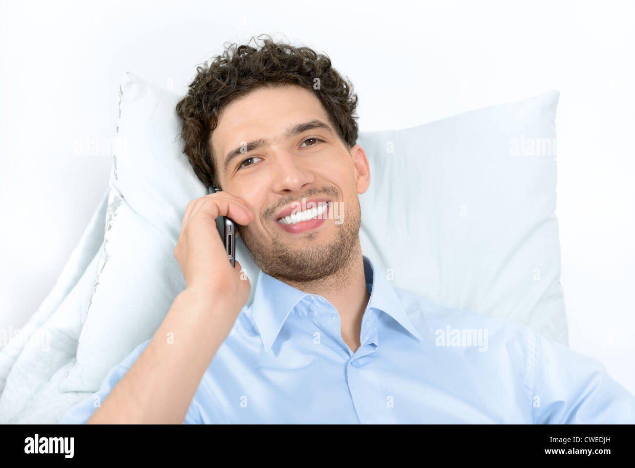 Young handsome man with mobile phone moderne. Studio shot. Banque D'Images