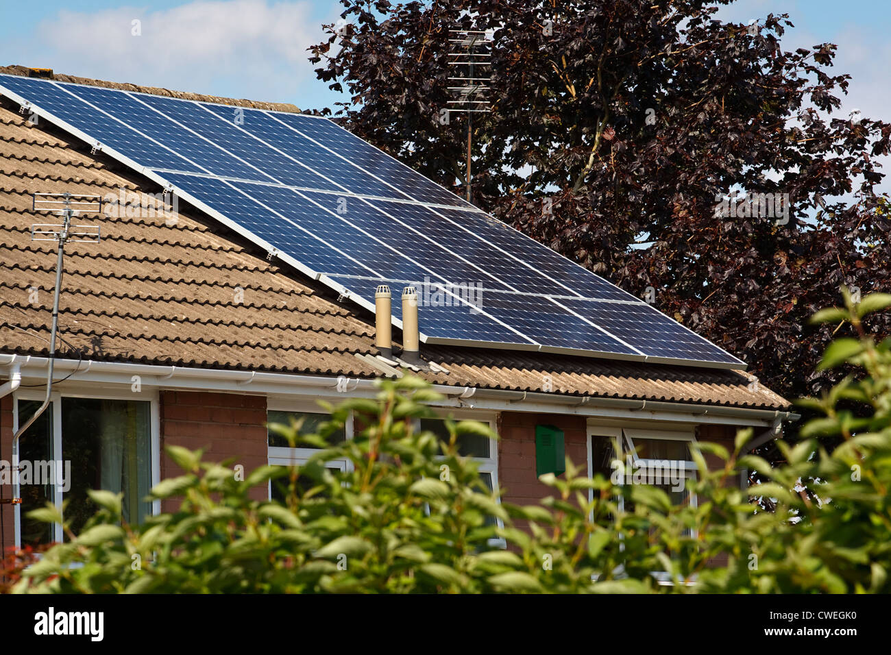 Panneaux solaires photovoltaïques montés sur un toit de tuiles de l'immeuble ou maison privée Banque D'Images