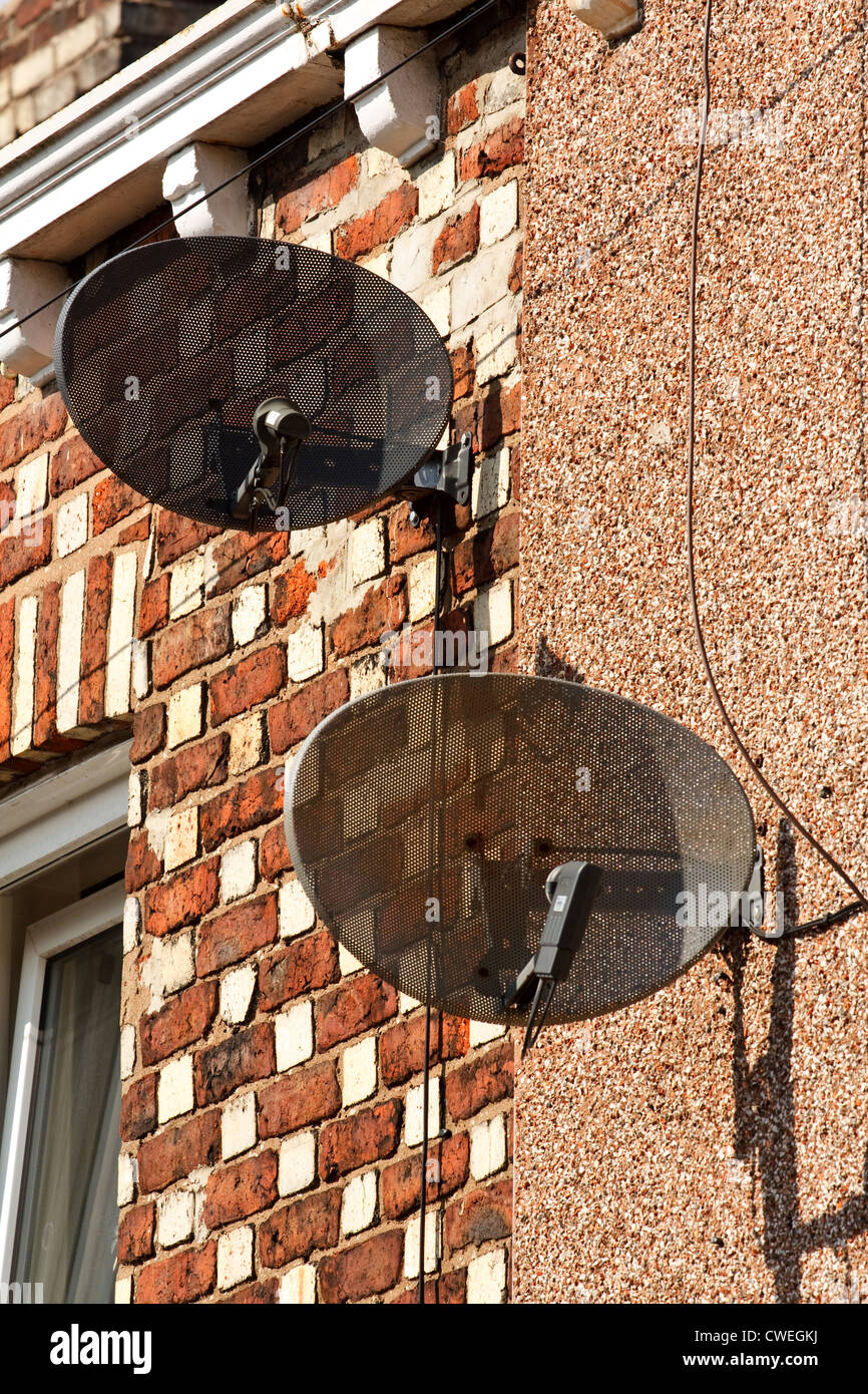 Des antennes paraboliques montées sur un bien immobilier résidentiel Banque D'Images