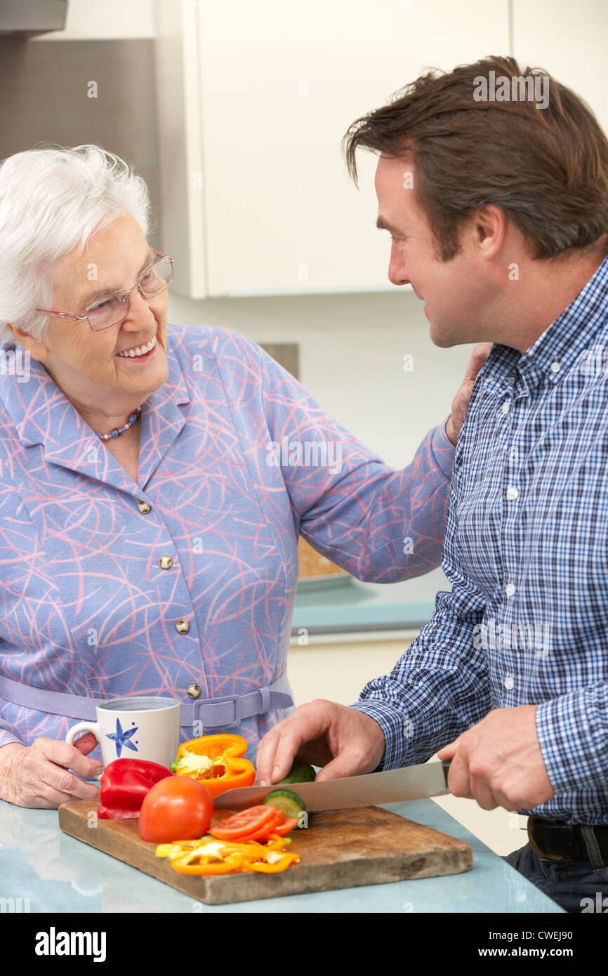 Mère et fils adultes la préparation de repas ensemble Banque D'Images