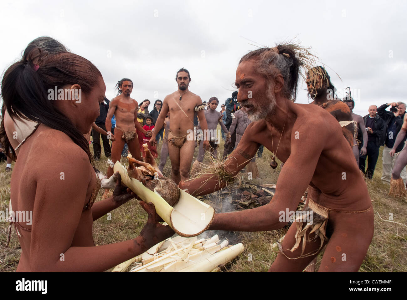 Shaman offrant de la nourriture aux jeunes femmes concurrent - Haka Pei - Île de Pâques Banque D'Images