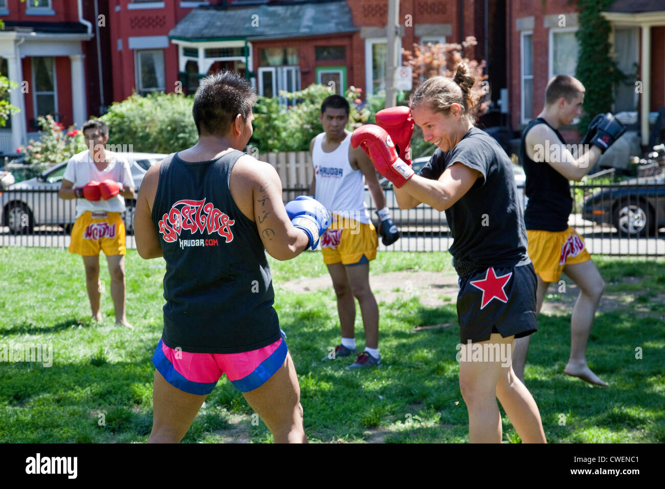 Un groupe de jeunes hommes et femmes pratiquent à l'extérieur dans un parc de la ville ou de Muay Thai Boxe Arts Martiaux dans Toronto;Ontario;Canada Banque D'Images