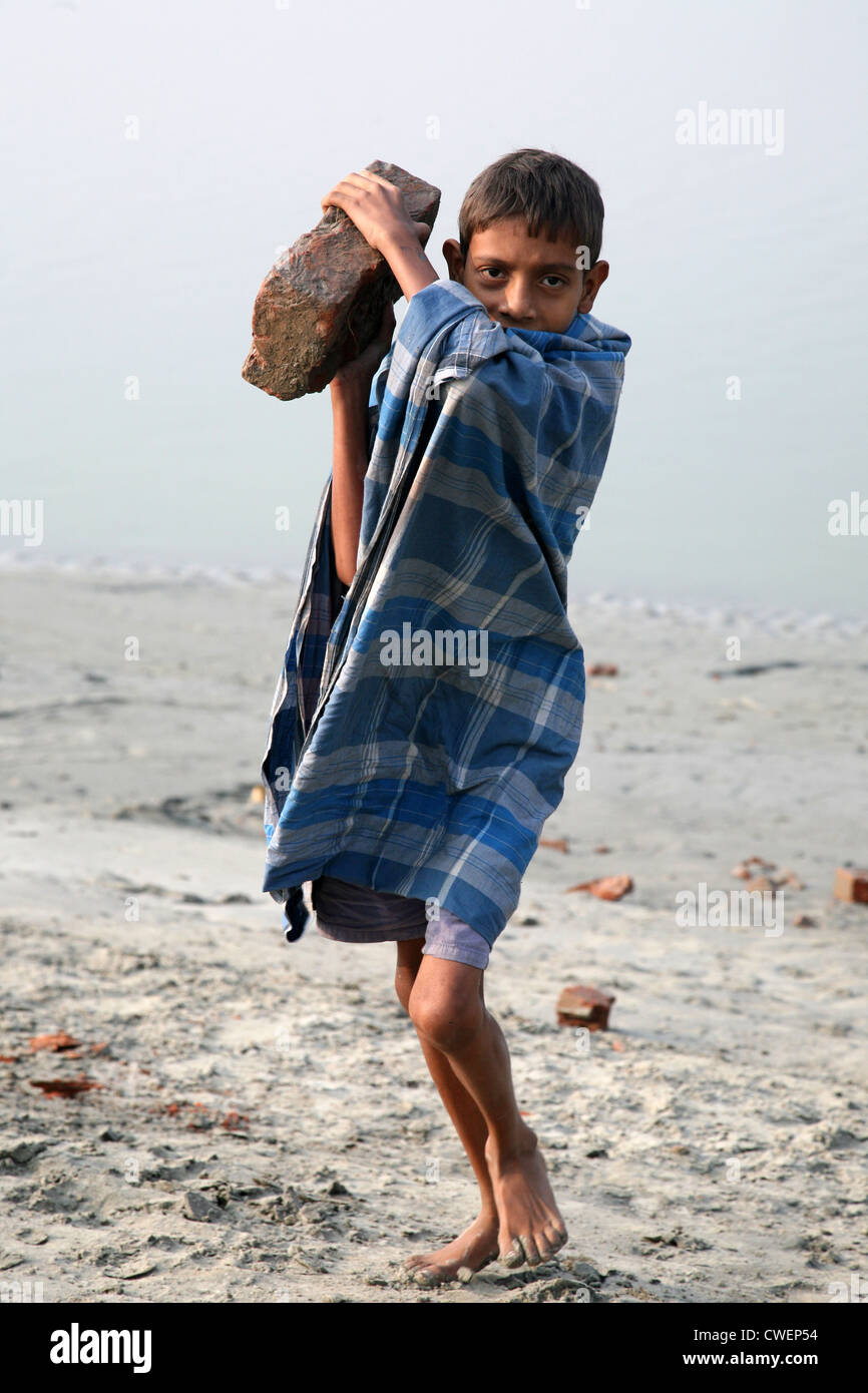 Des travailleurs portent des enfants transportant des briques sur sa tête en Sonakhali, Bengale occidental, Inde le 17 janvier 2009. Banque D'Images