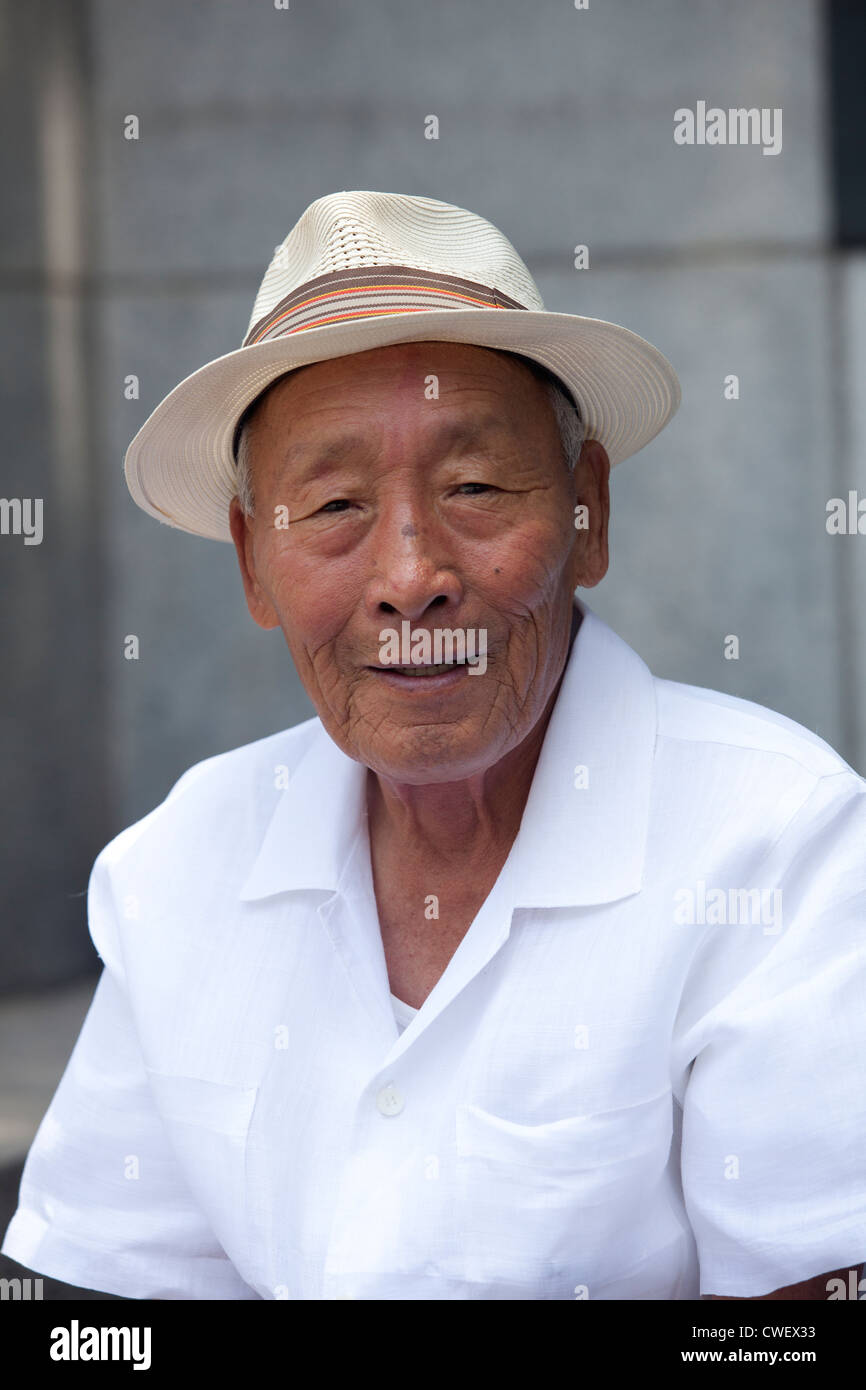 Un vieil homme coréen avec un chapeau dans un parc en Corée. Banque D'Images