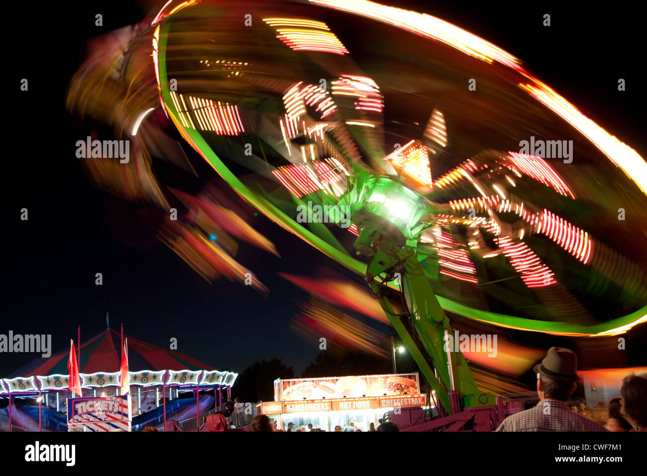 Lumières de Carnival Ride Blur contre Ciel Nocturne Banque D'Images