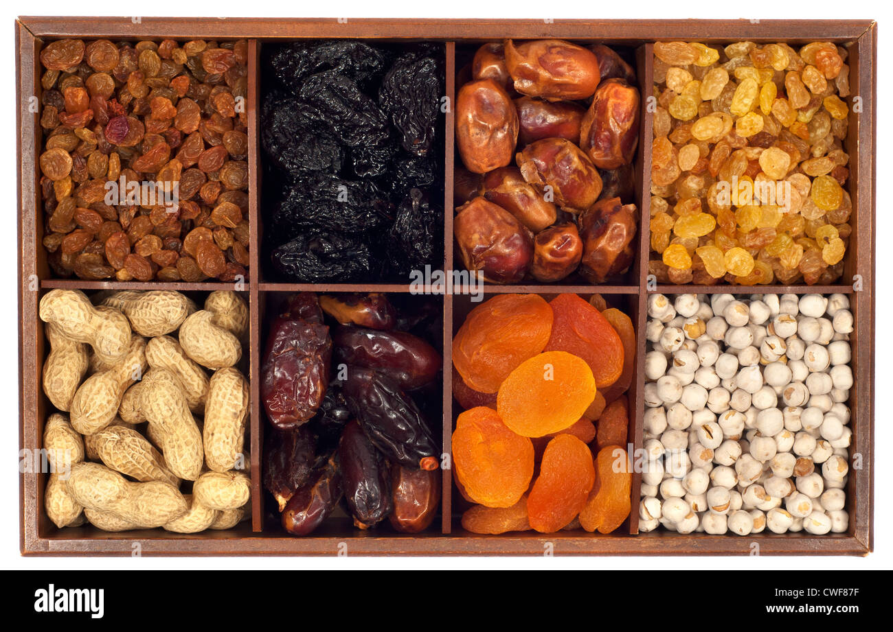 Un assortiment de fruits secs en boîte bois,isolé sur fond blanc.Raisin,prune,date,monkey-écrou, abricot, noix Banque D'Images