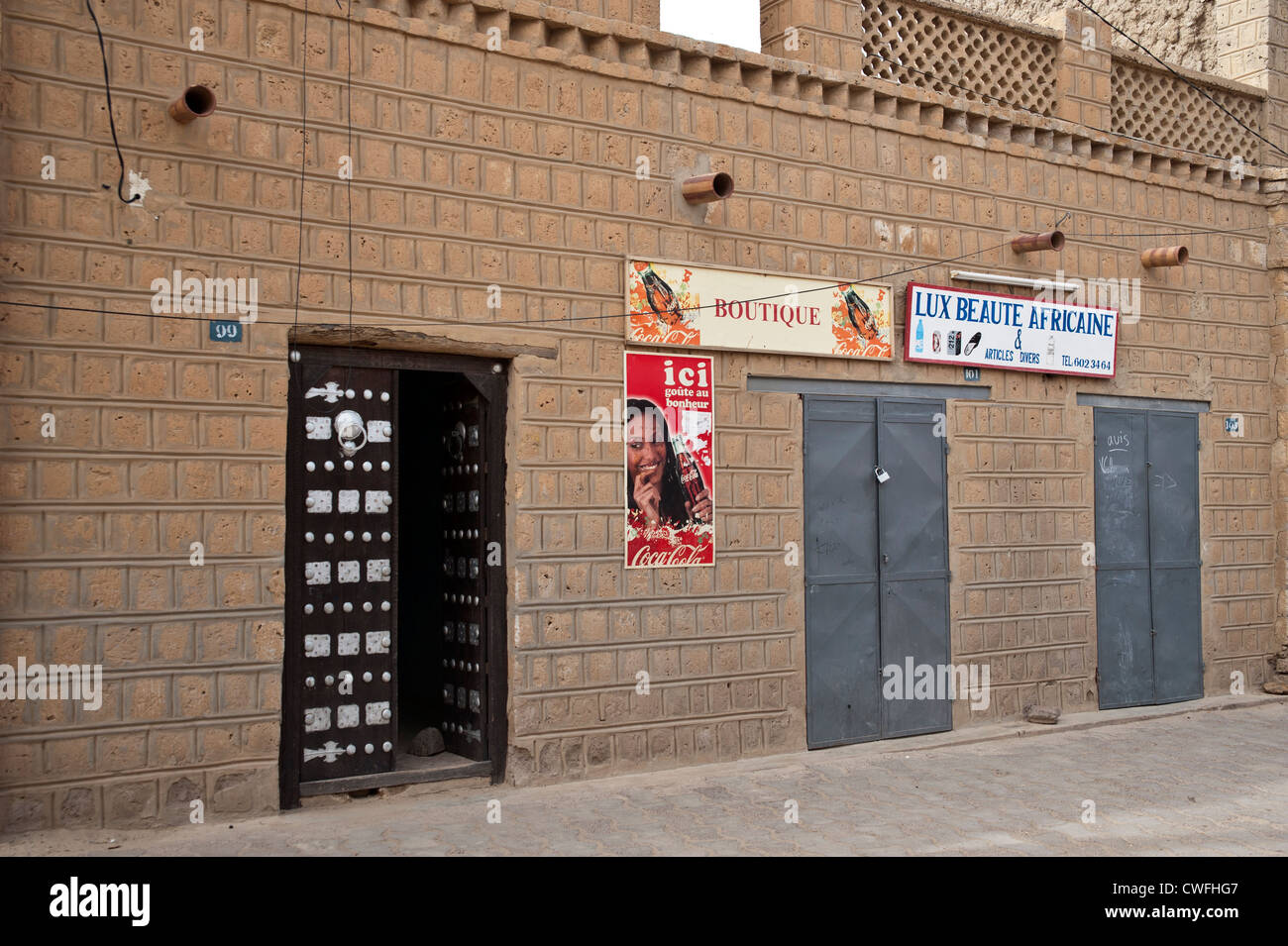 Rue de Tombouctou avec porte marocaine en relief et d'annonces collées sur  un mur d'une boutique Photo Stock - Alamy