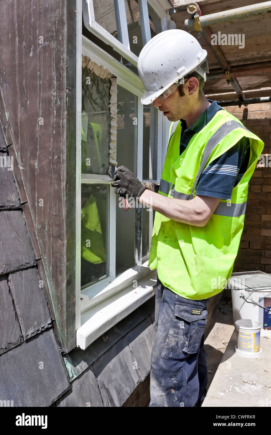 L'application de mastic vitrier une fenêtre sur un chantier de Londres  Photo Stock - Alamy